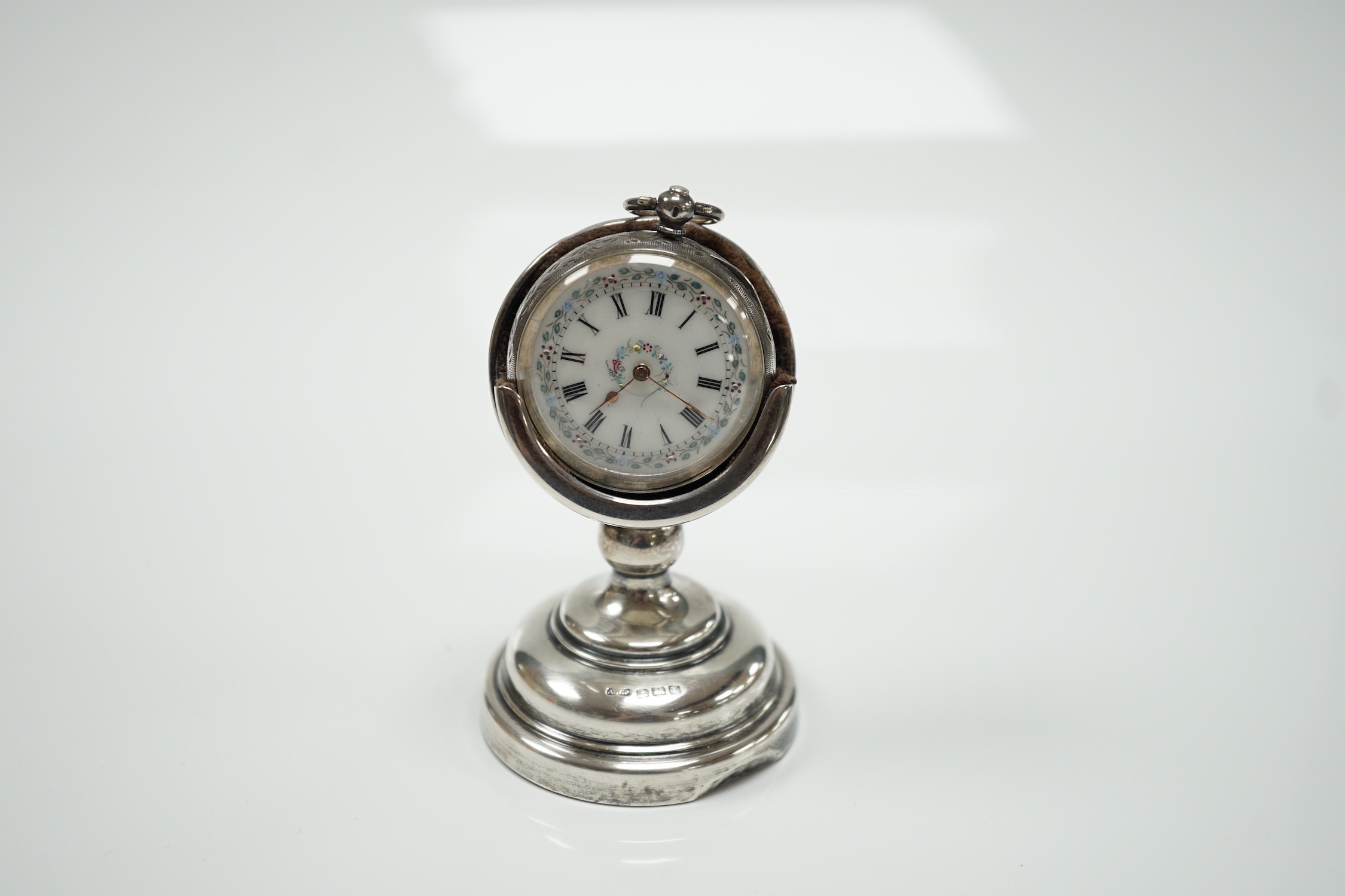 A George V silver mounted fob watch stand, Birmingham, 1923, 79mm, containing a Swiss white metal fob watch.